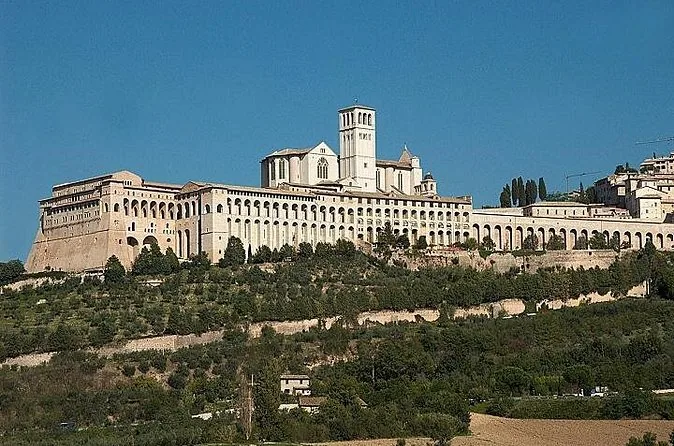 The Basilica of St Francis and the long arcades of its convent seen from the plain