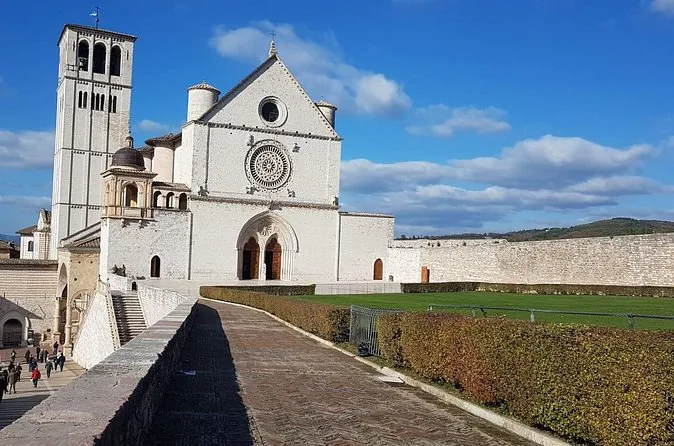 The white facade and bell tower of the Upper Church of St Francis above a lawn